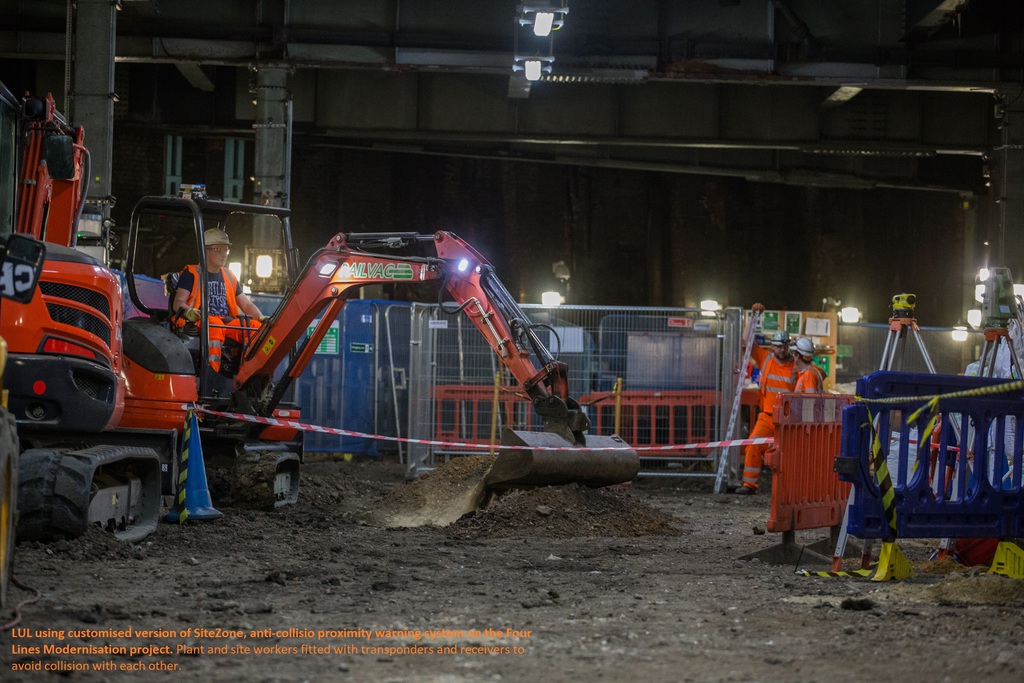 caption. lul customised sitezone system on digger & worker with tag at back of hard hat