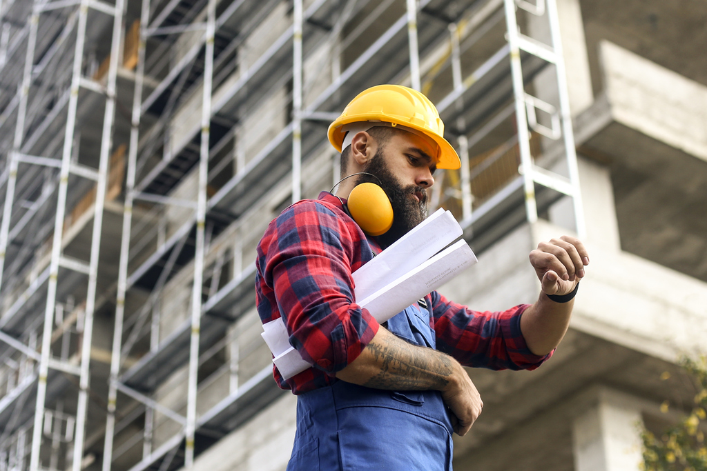 STOCK construction worker looks at watch 1284088208